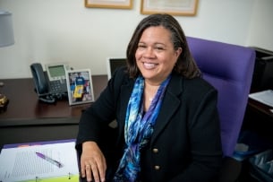 Whittier College president Linda Oubré, a woman with light brown skin and dark hair, pictured in an office.
